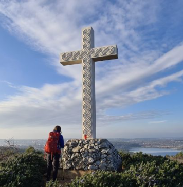 Female pilgrim in front of the cross at Way of the Cross on Camino South Istria, Medulin, Croatia, February 2022. Photo credit: Confraternity of St. James - Croatia